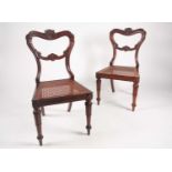 A pair of William IV solid rosewood crown backed side chairs with woven split cane panel seats. With