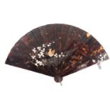 A Japanese tortoiseshell fan, Meiji period, decorated with a bird alighting on a blossoming prunus