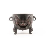 A Chinese patinated bronze circular charcoal brazier with pierced dog of fo mask and two lug