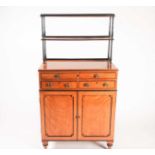 A Regency ebonised and figured satinwood chiffonier with a fitted secretaire frieze drawer, with