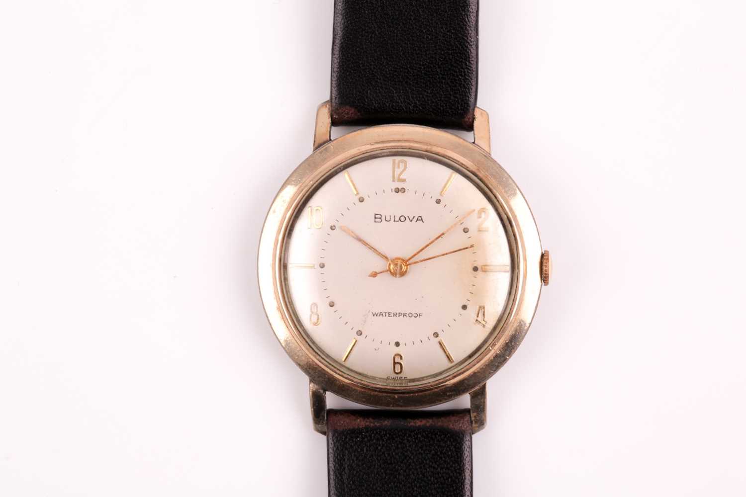 A Bulova mechanical wristwatch, the silvered dial with slim gilt numerals, in a gold cased case,