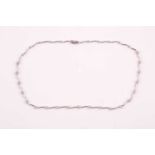 An 18ct white gold and diamond necklace, the curved bar-links set with floral clusters of round