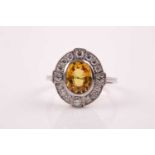 A platinum, diamond, and yellow sapphire ring, set with a mixed oval-cut sapphire of approximately