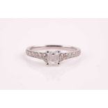 An 18ct white gold and diamond ring, set with an emerald-cut diamond of approximately 0.39 carats,