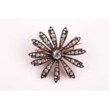 A late Victorian diamond brooch, centred with an old mine-cut diamond of approximately 6 x 5.5 mm,