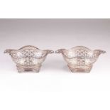 A Pair of Edwardian silver baskets. London 1902 by William Comyns; shaped oval form with twin ribbon