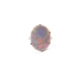 An 18ct yellow gold and black opal ring, set with a smooth, oval-shaped black opal measuring