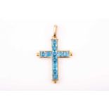 An 18ct yellow gold and blue topaz cross pendant, inset with mixed square-cut topaz, the cross