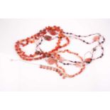 A triple strand carnelian beaded necklace, comprised of pale orange, red, andlighter carnelian, with