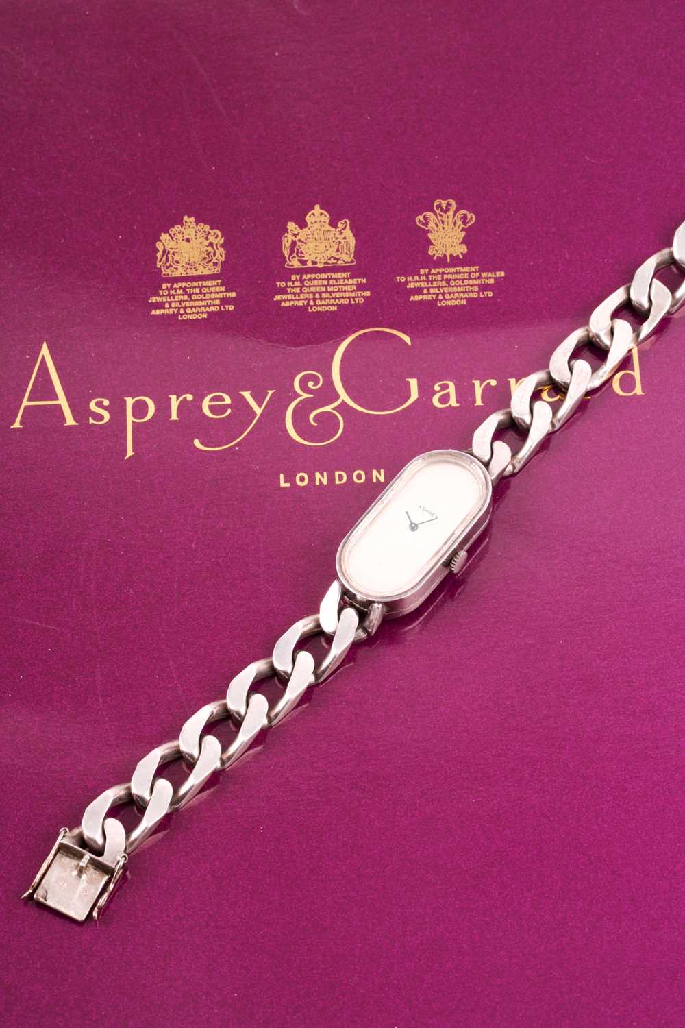 Asprey. A lady's silver wristwatch, the elongated oval brushed silvered dial with simple arrowhead - Image 14 of 18