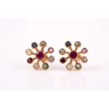 A pair of yellow metal and multi-gem earrings, the starburst style mounts set with rubies, emeralds,