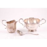 A silver sugar bowl the rim cast with shells and scrolling acanthus leaves the two handles in beaded