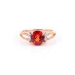 A 9ct yellow gold, diamond, and orange sapphire ring, set with a mixed oval-cut sapphire of