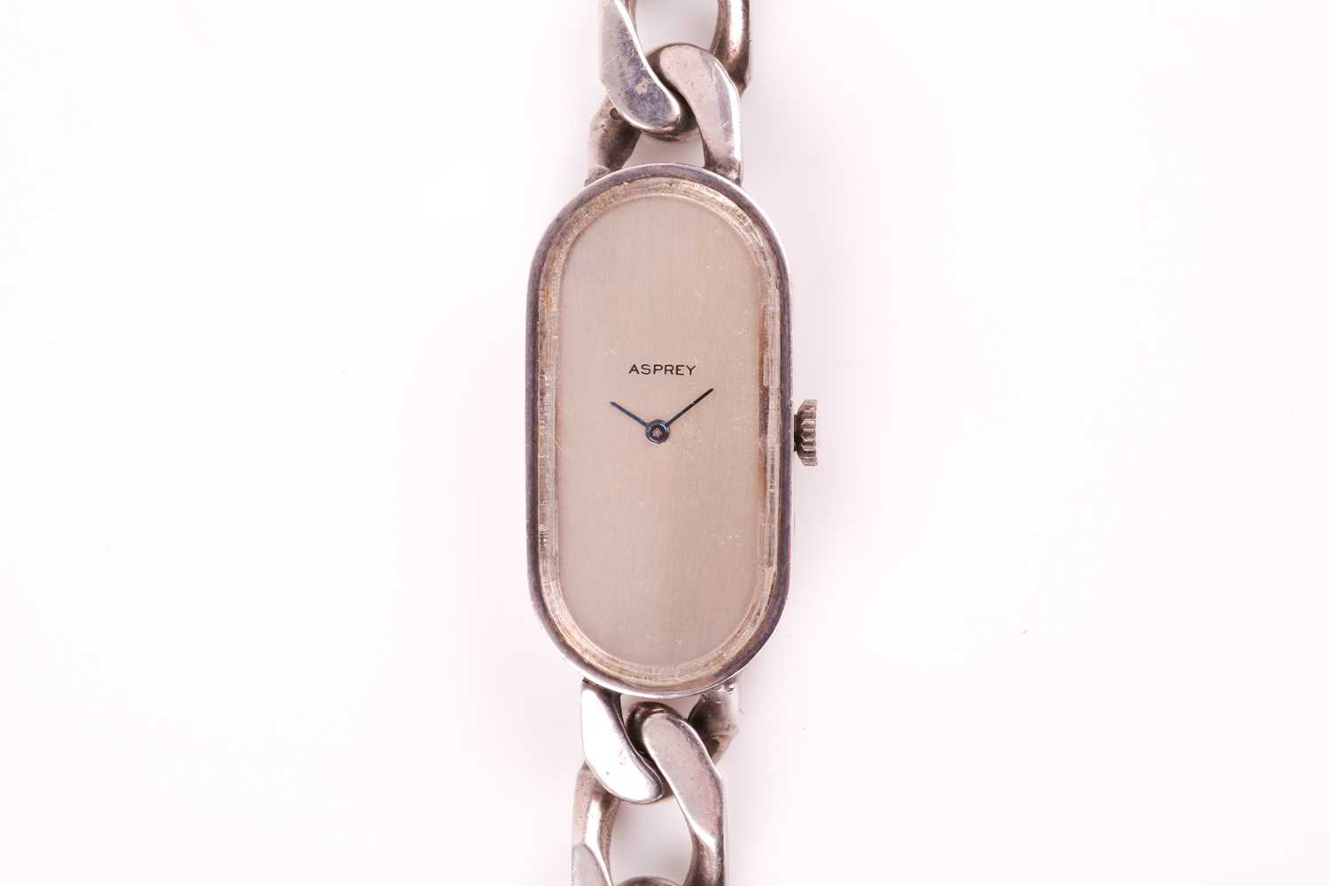 Asprey. A lady's silver wristwatch, the elongated oval brushed silvered dial with simple arrowhead