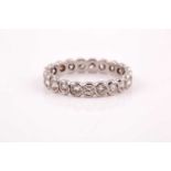 A diamond eternity ring, rubover set with twenty one round brilliant-cut diamonds of approximately