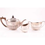 A bachelors silver three piece tea service, with half reeded body, engraved with two family