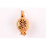 An 18ct yellow gold and ruby pomegranate pendant, an open segment pave-set with round-cut rubies,