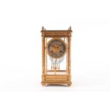 A late 19th century gilt brass and four glass mantel clock, with silvered circular dial and twin