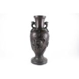 A large bronze Japanese ring-handled vase, with relief decoration depicting lions amongst foliage,