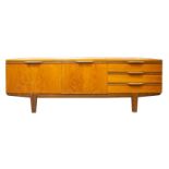 A large Uniflex teak sideboard, circa early 1970's, fitted with three drawers, a fall front cocktail