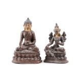 A Tibetan patinated bronze figure of a Buddha seated on a double lotus socle with hands in the