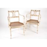 A pair of Sheraton style ivory painted and parcel-gilt open armchairs, probably c1900, with