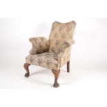 A George I style walnut "Wig" armchair, C1900. With scroll arms and concave back. Supported by