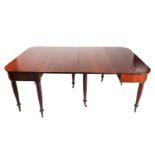 A George IV mahogany double "D" ended extending dining table. Each end with a drop-leaf section