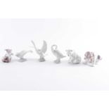 A Lladro porcelain figure of a seated beagle puppy 16 cm long Together with three Lladro swans, a