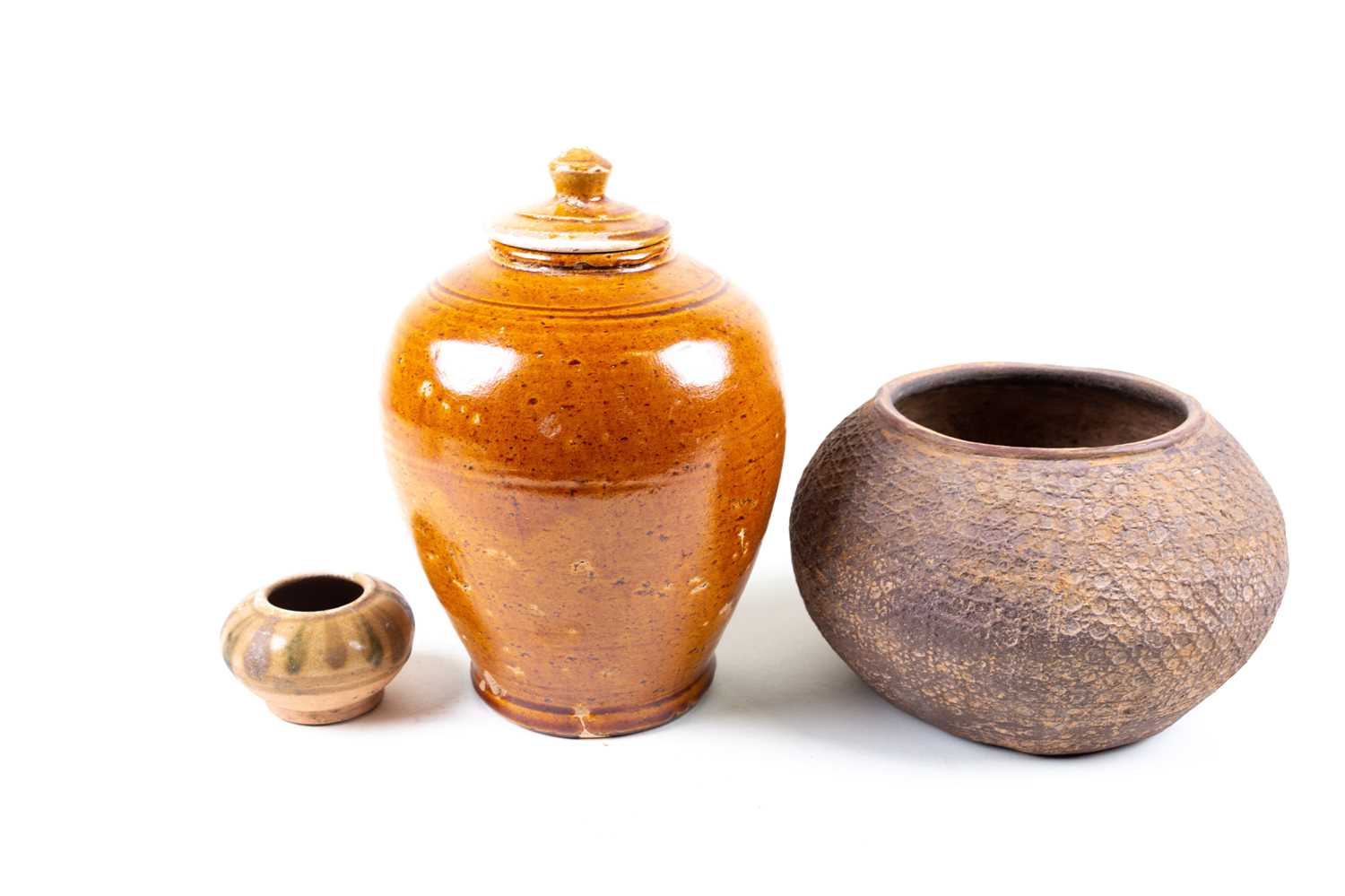 Tang ceramics. A toffee - glazed vase and cover of ovoid form, rings at the shoulder and with