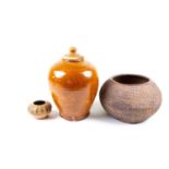 Tang ceramics. A toffee - glazed vase and cover of ovoid form, rings at the shoulder and with
