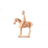 A Chinese pottery figure of a horse and rider, Tang dynasty, possibly a military figure wearing a