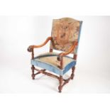 A French Louis XIV style walnut open armchair with stuff over armorial pettit point upholstery.