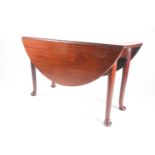 An early George III mahogany oval drop leaf dining table on turned supports with pad feet. 125 cm