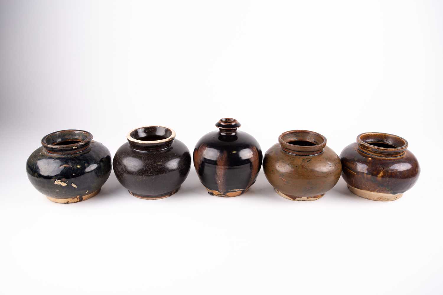 Five Chinese Henan jarlets, with various brown to black glazes, one with a short neck and