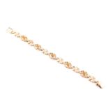 A five stone citrine bracelet, the oval cut stones in pierced fancy figure of eight links to a