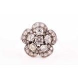 A platinum and diamond floral cluster ring, set with six round-cut diamonds to the centre, of