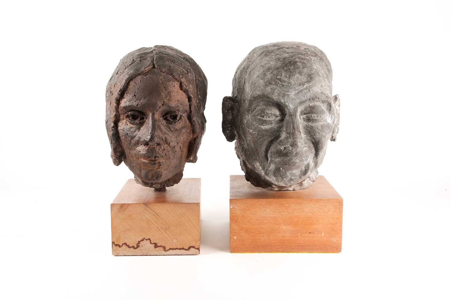 A stoneware bust of a elderly lady, her hair in a bun, in a bronzed finish, and a bust of an elderly