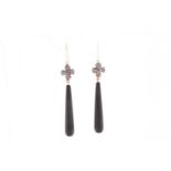 A pair of diamond and onyx drop earrings, with tapered black onyx drops, beneath a diamond and