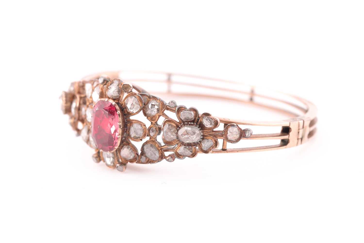 An antique yellow metal and diamond bangle, set with a reddish pink central stone, likely spinel, - Image 4 of 6