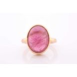 An 18ct yellow gold and tourmaline ring, set with an oval cabochon pink tourmaline, measuring