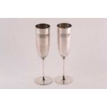 A pair of commemorative limited edition silver champagne flutes; with applied plaques reading '