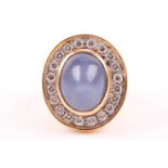 An 18ct yellow gold, diamond, and star sapphire cocktail ring, set with a domed cabochon sapphire,