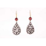 A pair of diamond and garnet earrings, the openwork pear-shaped silver mounts inset with rose-cut