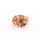 A yellow metal, pearl, and lapis ring, possibly made in Switzerland, the openwork mount set with