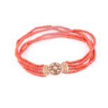 A four strand coral choker necklace, fastened with a Continental yellow metal clasp, the roundel