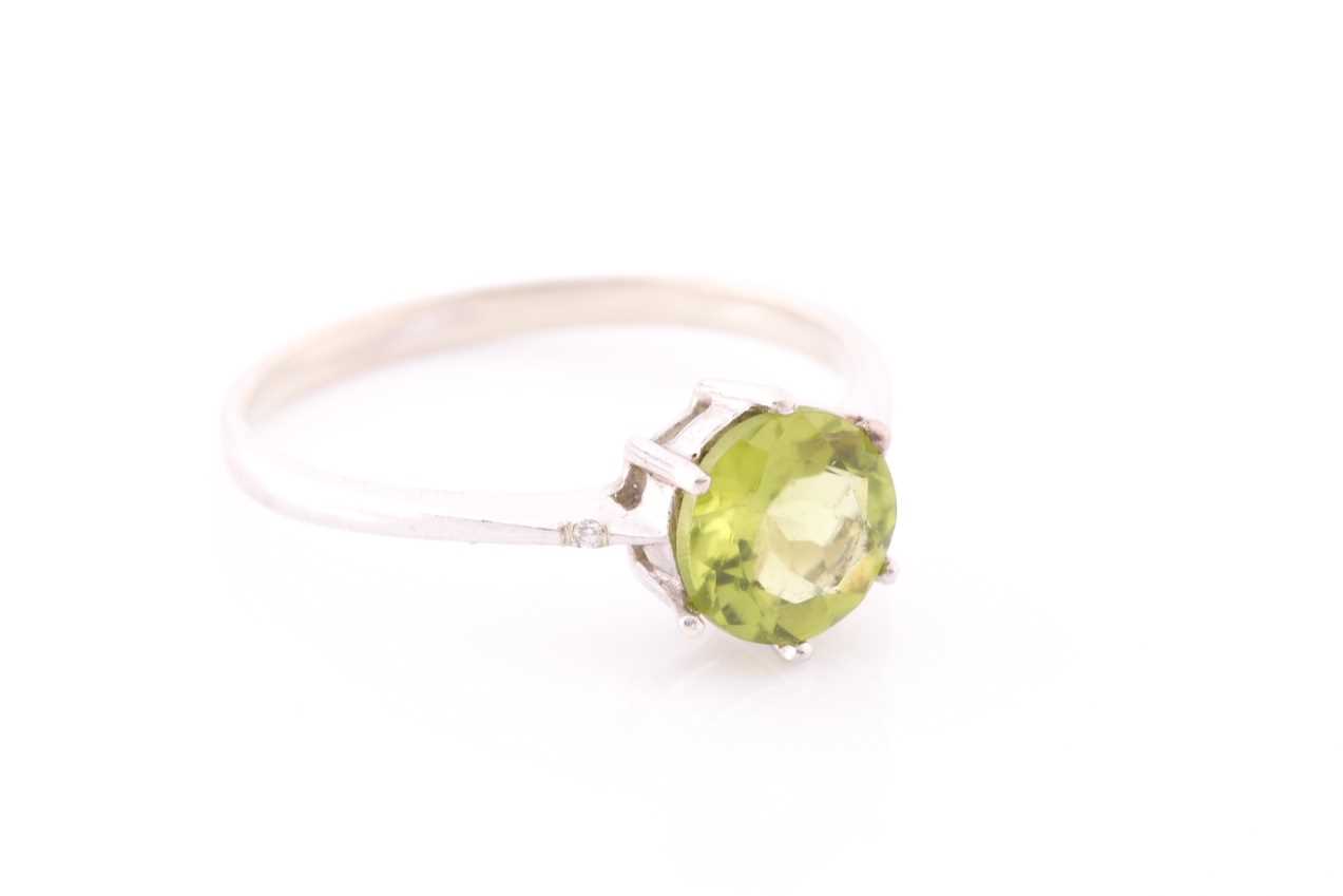 A peridot and diamond ring, centred with a mixed round-cut peridot, approximately 7.6 mm diameter, - Image 2 of 4