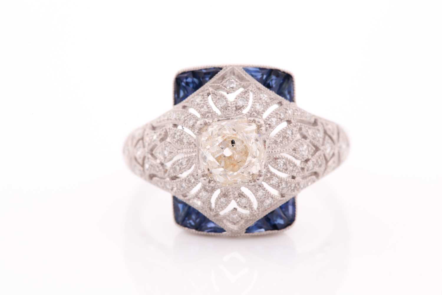 An unusual diamond and sapphire ring, in the Art Deco style, centred with an old cushion-cut