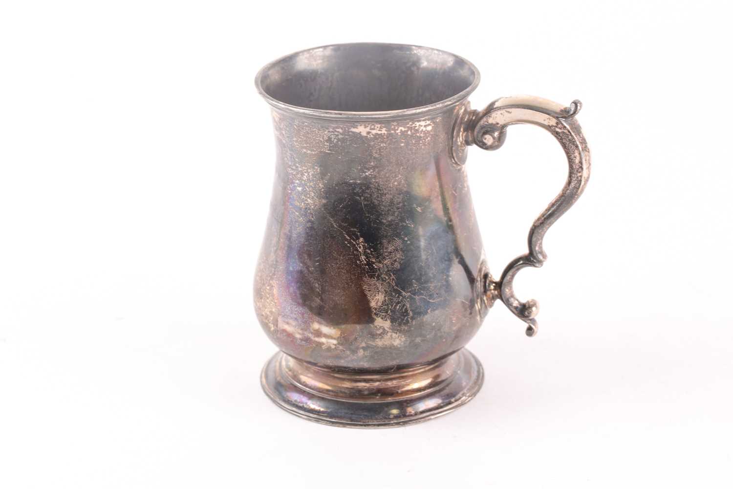A George III silver baluster tankard with capped double scroll handle. London 1761 by William and