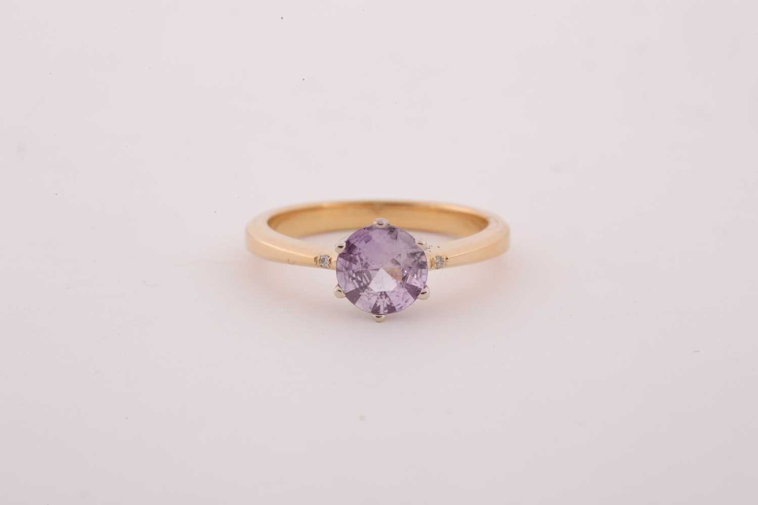 An 18ct yellow gold and solitaire sapphire ring, set with a mixed round-cut pink sapphire,